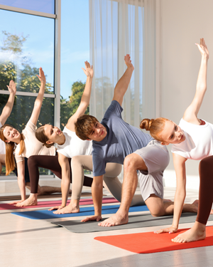 A group of teenagers stretching on yoga mats.