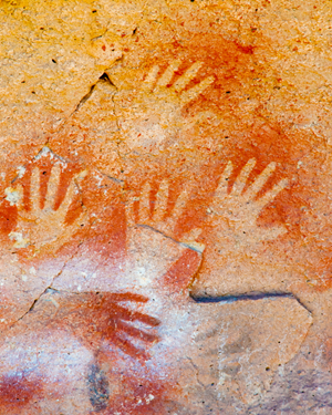 Hand prints on a rock wall.