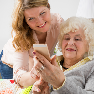 Young Girl helping and olderwoman with her phone.
