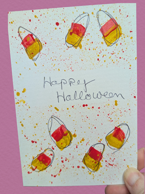 White Halloween card with drawn candycorn painted in watercolors.